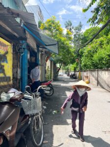 道を歩くおばあさんの写真。ベトナム・ホーチミンで労働許可証のための健康診断前に散歩。